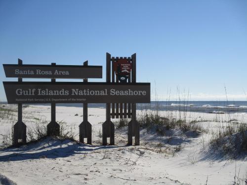 a sign in the sand at the beach at Romantic condo for 2-Sunset Harbor Palms 1-205, pool, fishing pier in Navarre