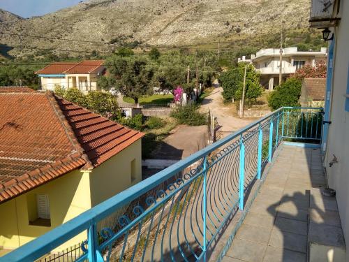 a balcony of a house with a blue fence at Valta's Room in Paleros