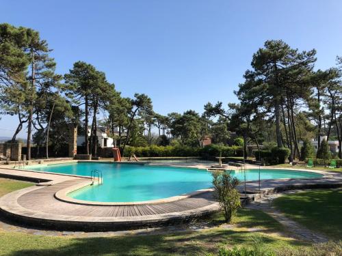 a large swimming pool in a park with trees at Bungalow B2 - Nature, Beach & River in Ofir