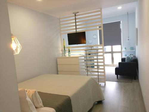een kleine slaapkamer met een bed en een keuken bij V4 in Horta