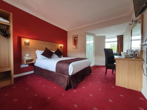 Apollo Hotel في برمنغهام: غرفة الفندق بسرير كبير ومكتب
