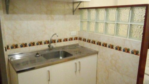 uma cozinha com um lavatório e uma janela em Posada Gino em Pisco