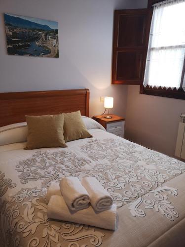 a bedroom with a bed with towels on it at Apartamentos La Tarazana 2 in La Pereda de Llanes