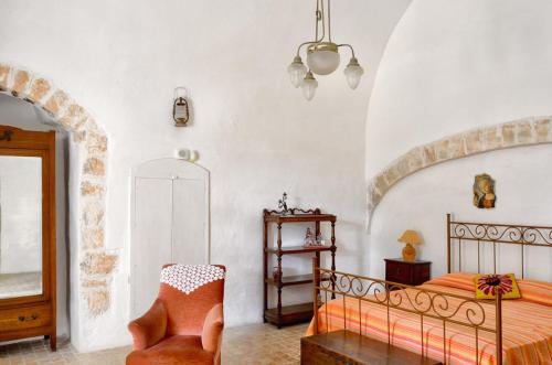 sypialnia z łóżkiem i krzesłem w obiekcie Agriturismo Antonelli Piangevino w mieście Monopoli