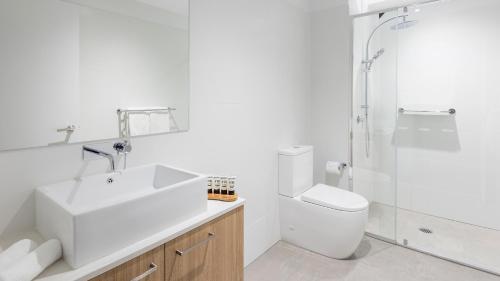 a bathroom with a sink and a toilet and a shower at Avani Adelaide Residences in Adelaide