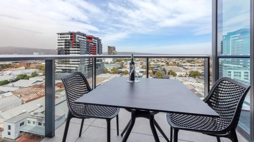 a table and chairs on a balcony with a view at Avani Adelaide Residences in Adelaide