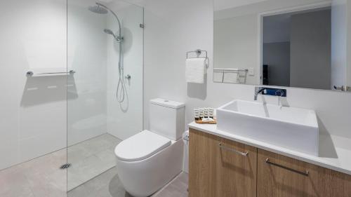 a bathroom with a toilet and a sink and a shower at Avani Adelaide Residences in Adelaide
