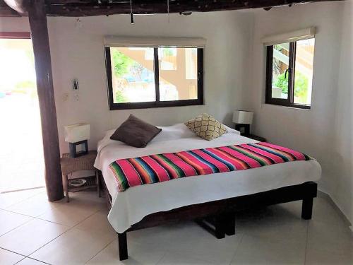 sypialnia z łóżkiem z kolorowym kocem w obiekcie CASA TORTUGA, Soliman Bay w mieście Tulum