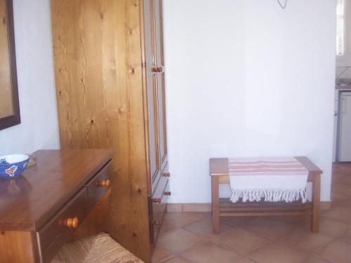 a room with a wooden dresser and a wooden table at Votsalo Apartments in Naousa