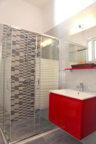 a bathroom with a red sink and a shower at George apartment in Artemida