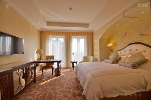 a hotel room with a large bed and a desk at Urban Island Hotel Shanghai in Jiading