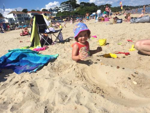 a little girl playing in the sand on the beach at Turlin Valley in Poole