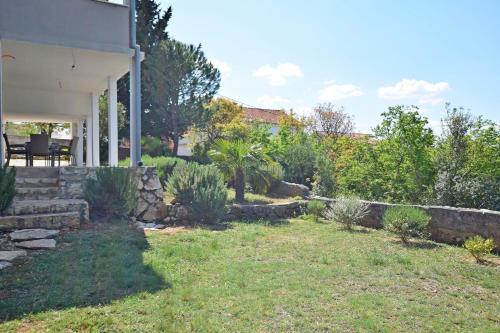 a yard of a house with a stone wall at Apartment Lavanda in Kruševo