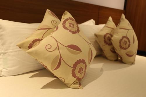 a group of pillows sitting on top of a bed at HOTEL MADNI ROYALE (50 Mtrs from Dargaah), Ajmer in Ajmer