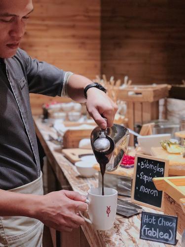 a person is pouring coffee into a cup at Hotel XYZ in Tacloban