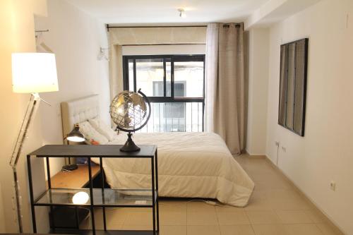 a bedroom with a bed and a table and a window at Sunny Apartments, Historical Centre Alicante in Alicante