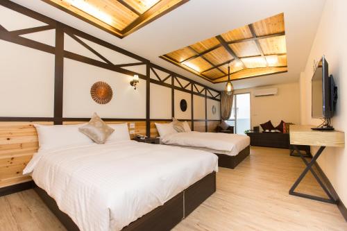 een slaapkamer met 2 bedden en een flatscreen-tv bij 17th Summer in Pinghe