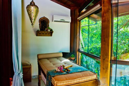 a living room with a couch and a window at Pousada Bora Bora in Bombinhas