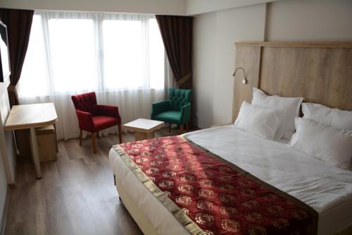 a hotel room with a bed and two chairs at DEVREK OTEL in Zonguldak