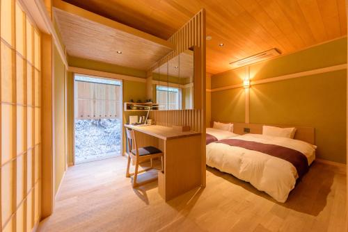 a bedroom with a bed and a desk and a window at Hanaikada in Kyoto
