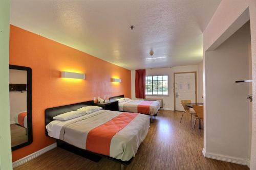 a hotel room with two beds and a table at Motel 6-Edinburg, TX in Edinburg