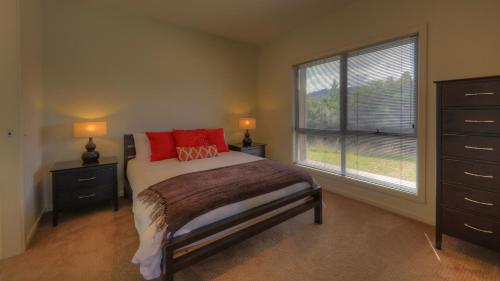 a bedroom with a bed with red pillows and a window at Tides Reach in Dover