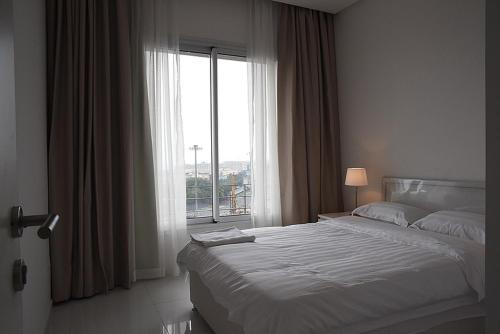 クウェートにあるCode housing - Al Bedaa- Family onlyのベッドルーム1室(ベッド1台、大きな窓付)