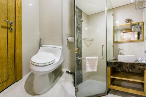 a bathroom with a toilet and a glass shower at The Blue Airport Hotel in Ho Chi Minh City