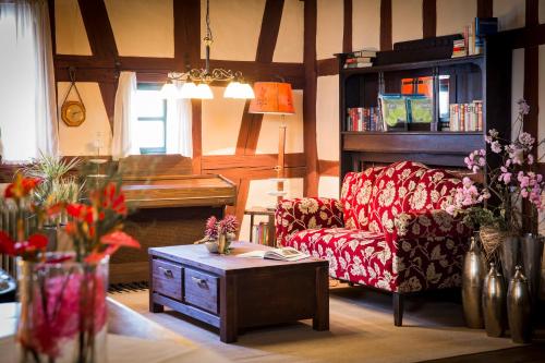 a living room with a couch and a piano at DER SCHWAN Hotel & Restaurant in Schwanstetten