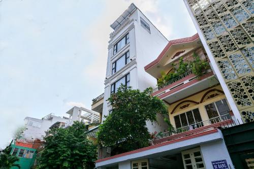 a tall white building with trees in front of it at The Blue Airport Hotel in Ho Chi Minh City