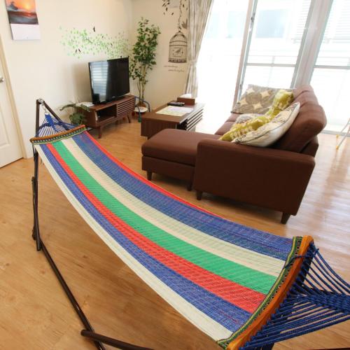 a hammock in the middle of a living room at Alaha Blue Resort 6F -SEVEN Hotels and Resorts- in Chatan