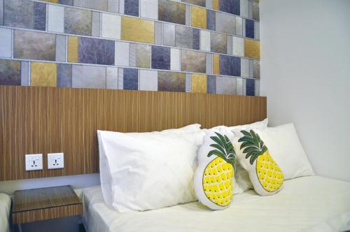 Un dormitorio con una cama con almohadas de piña. en Tas 96 Inn, en Kuantan