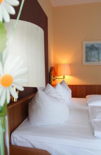 a hotel room with two beds with white pillows at Reichels Parkhotel in Bad Windsheim