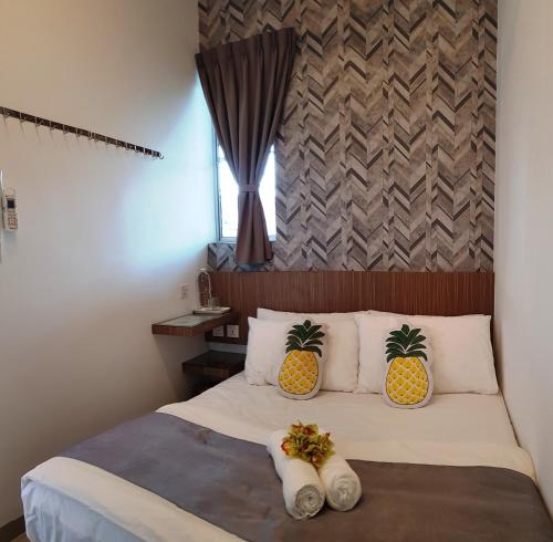 a bedroom with a bed with two pineapple pillows at Tas 96 Inn in Kuantan