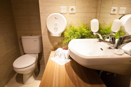 a bathroom with a toilet and a sink at Wood Hotel Bandung in Bandung