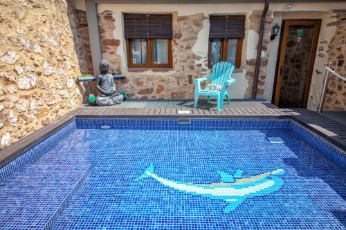 a swimming pool with a blue chair next to a house at Valterra y Tosal in Torres-Torres