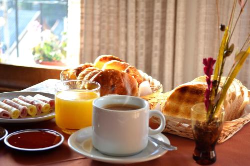 une table avec une tasse de café et un panier de viennoiseries dans l'établissement Hostería Güemes, à San Carlos de Bariloche