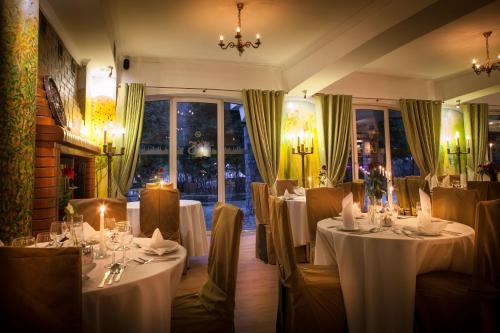 a room with tables and chairs in a restaurant at Hotel Las Piechowice in Szklarska Poręba