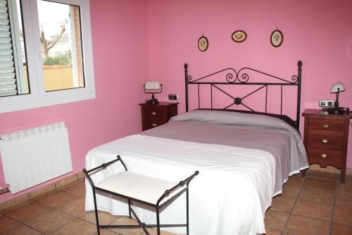 a pink bedroom with a bed and a chair at Chalet con piscina privada en zona tranquila de Cambrils in Cambrils