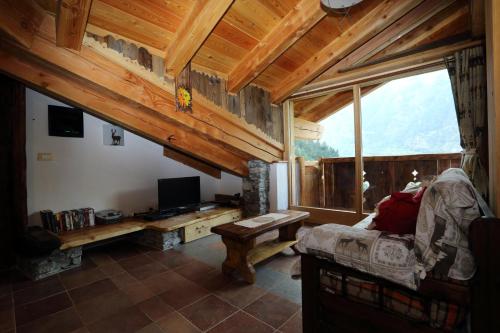 a living room with a couch and a television in a cabin at La Cincia in Morgex