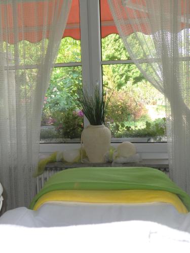 a bed in front of a window with a green blanket at Haus Marija M in Badenweiler