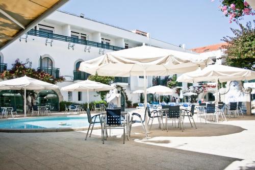 a group of chairs and umbrellas next to a pool at Hotel Suave Mar in Esposende