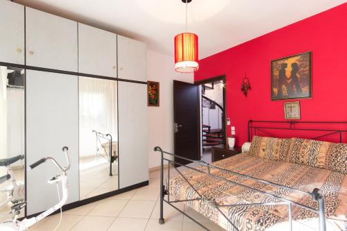 Un dormitorio con una pared roja y una cama en Villa Efi en Skala Rachoniou