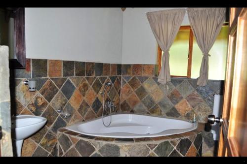 a bathroom with a bath tub and a sink at Mothopo Game Lodge in Modimolle