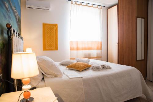 a bedroom with a white bed with a lamp and a window at Villa Diana affitta camere in Stintino