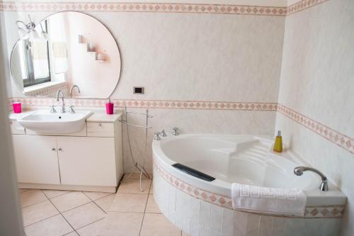 a bathroom with a tub and a sink and a mirror at Villa Diana affitta camere in Stintino
