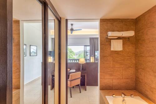 a bathroom with a shower and a sink and a desk at Camar Resort Langkawi in Pantai Cenang