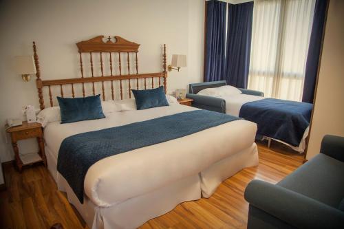 a hotel room with two beds and a chair at Palacio Azcárate Hotel in Ezcaray