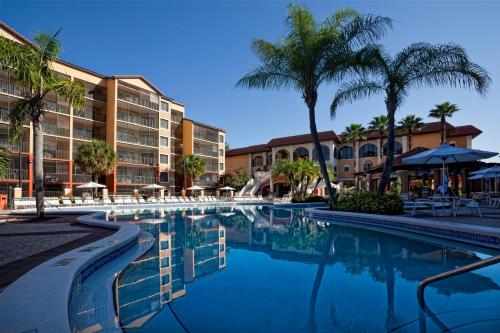 a pool at a resort with palm trees and buildings at Westgate Lakes Resort and Spa in Orlando