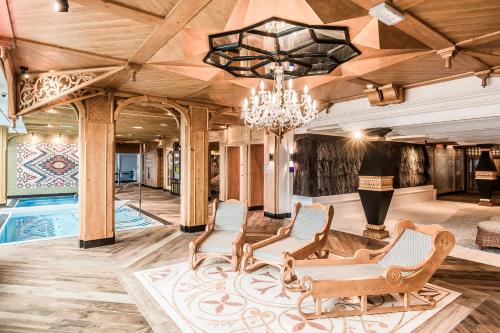 a living room with a chandelier and a pool at Bachleda Hotel Kasprowy in Zakopane